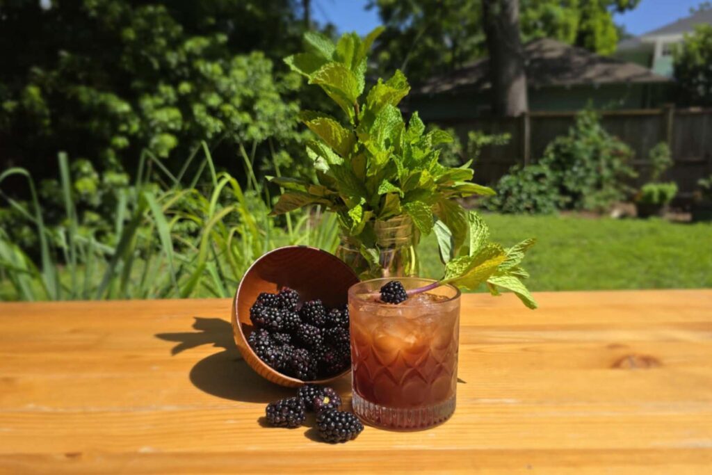 We Demand a Shrubbery craft cocktail with blackberries and mint in a rocks glass