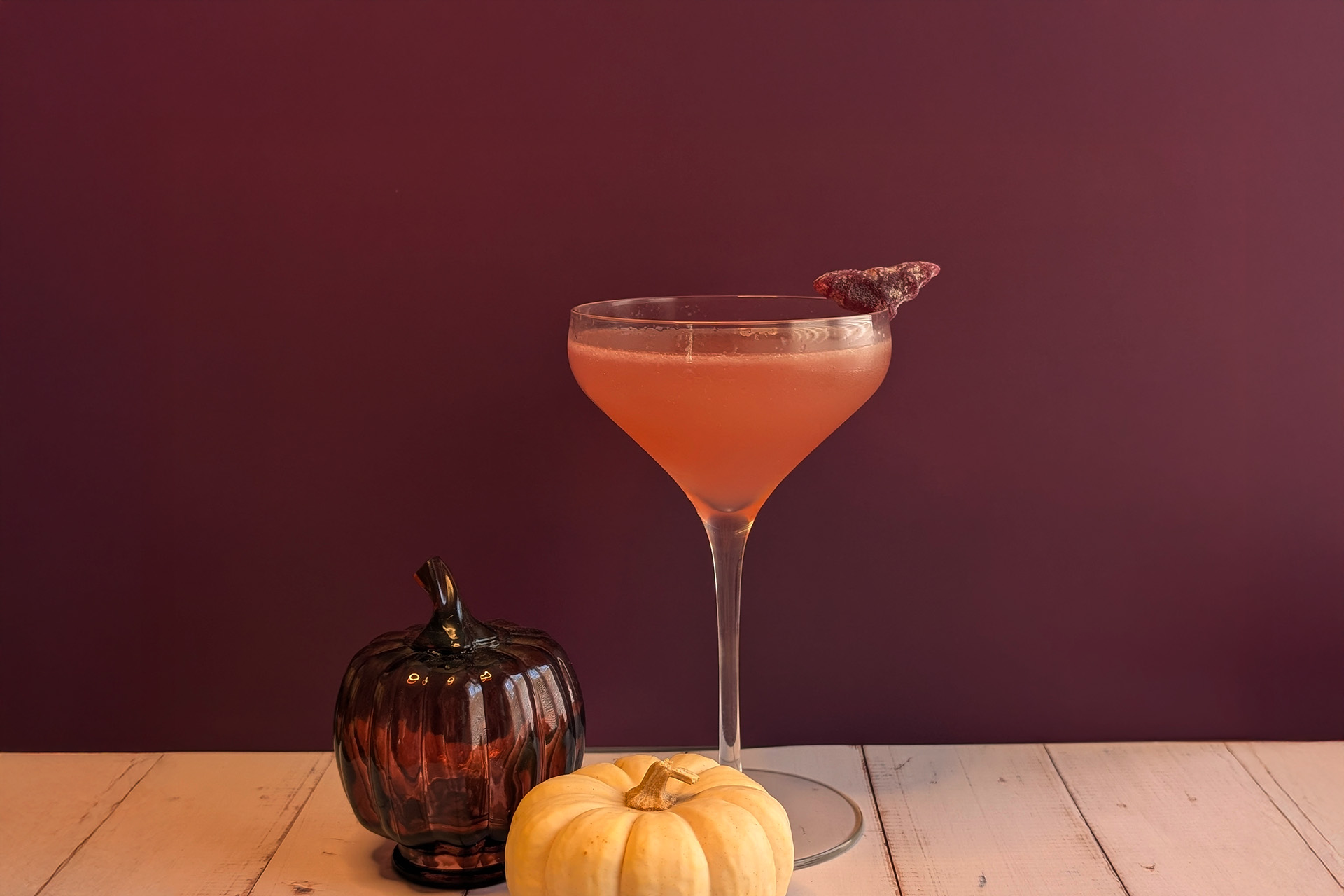 daiquiri cocktail with sour candy garnish and pumpkins surrounding; halloween cocktails